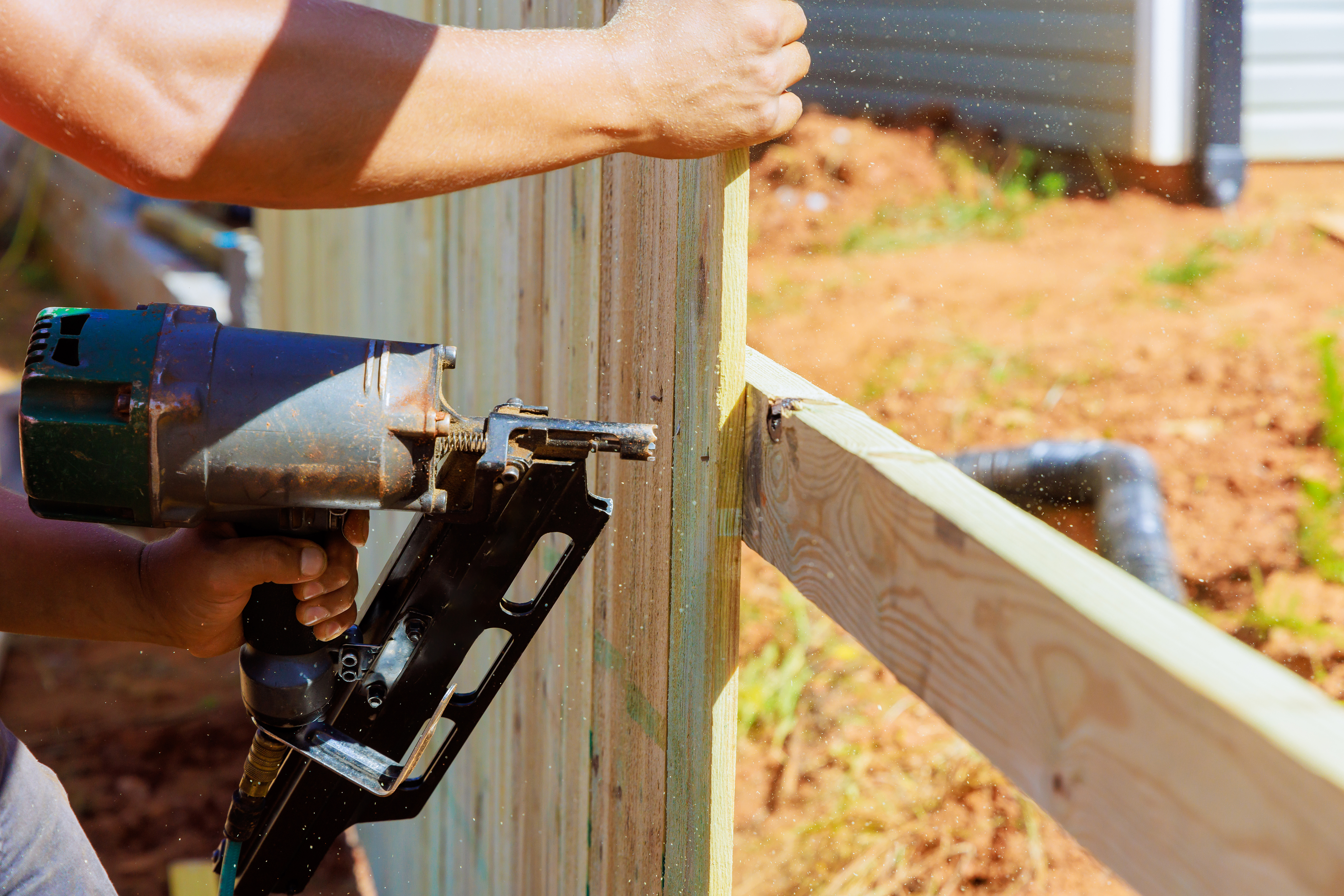 Wooden privacy fence with vertical boards installed along a residential property line
